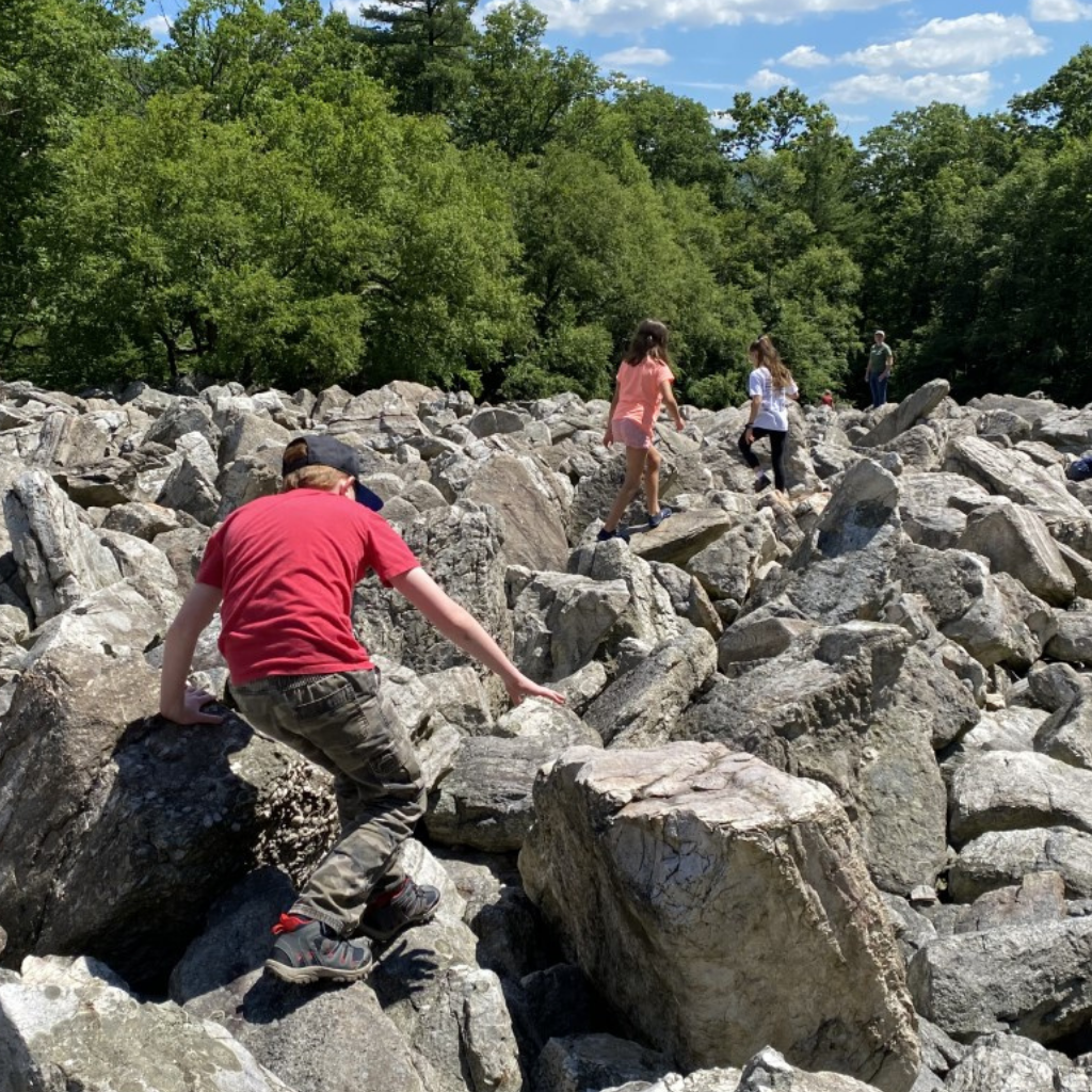 Campers hiking on boulders at summer camp