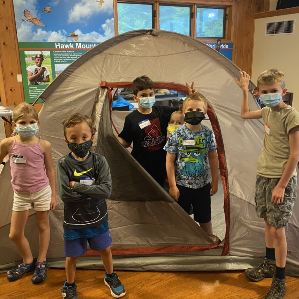 Campers standing inside of a tent at summer camp