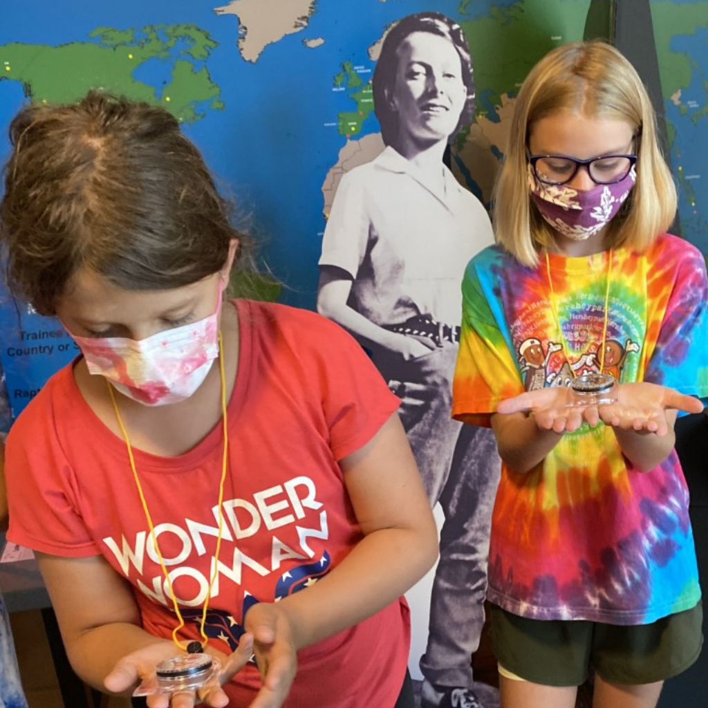 Campers using a compass at summer camp Campers using a compass at summer camp