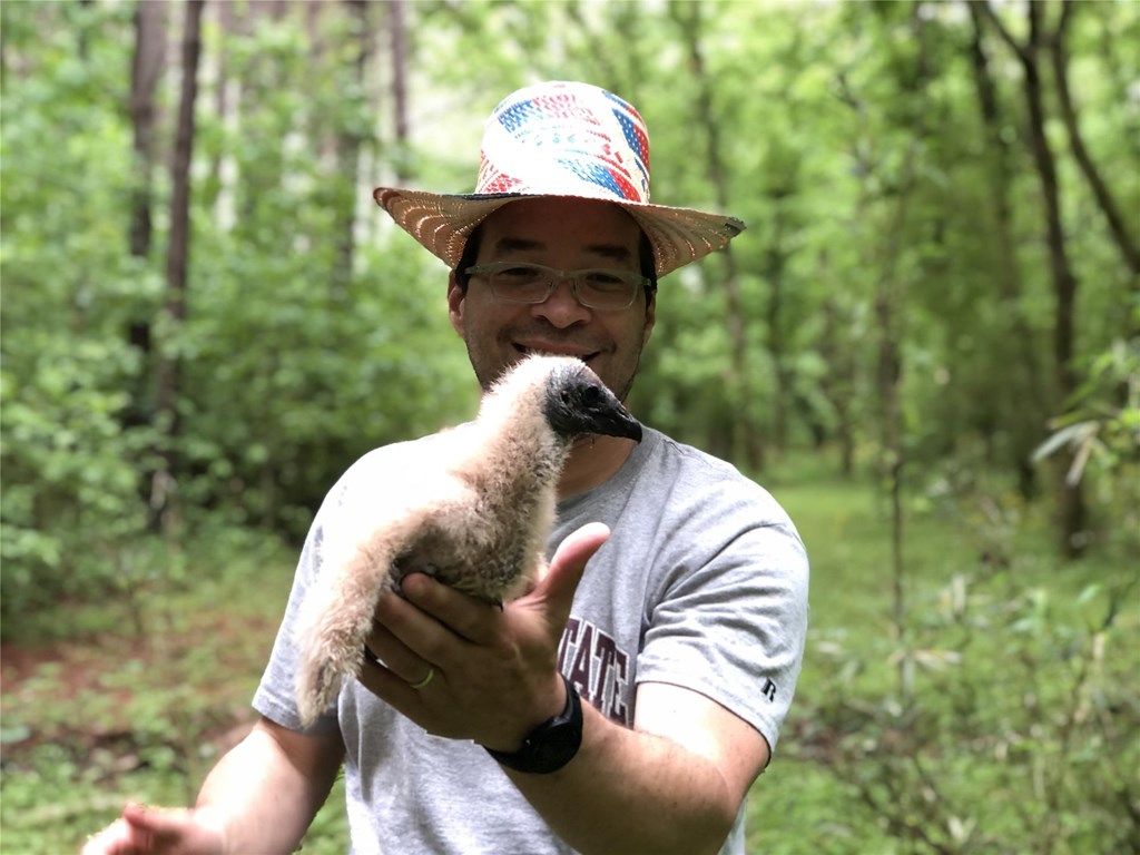 Adrian Naveda holding a vulture chick