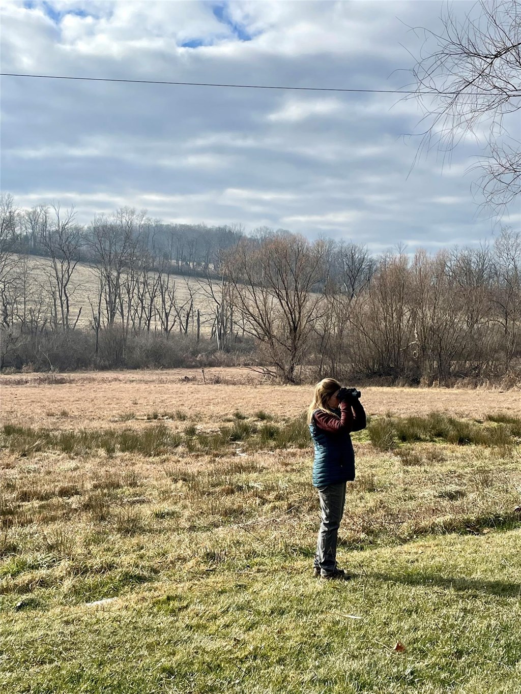 Laurie with binoculars in a Hawk Mountain adjacent field, CBC 2022