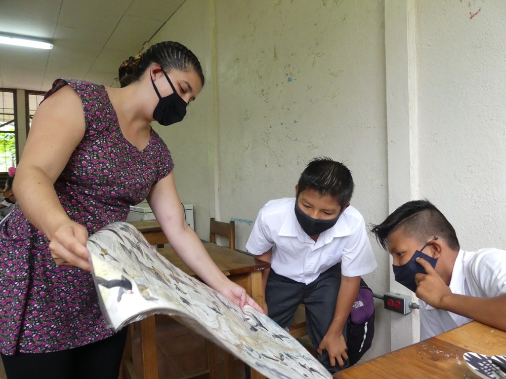 Pamela Carvajal showing raptor poster to students 