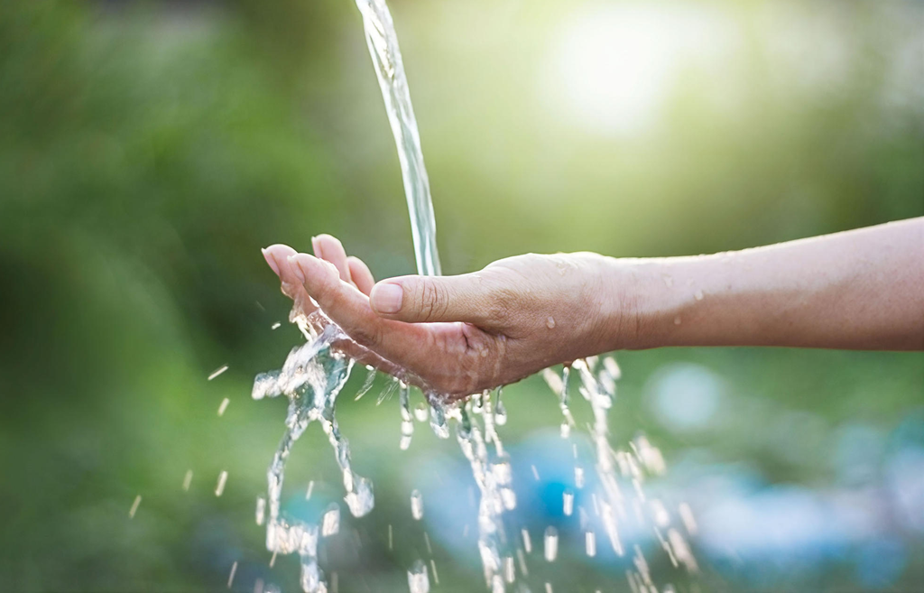 Water pouring into open hand Water pouring into open hand