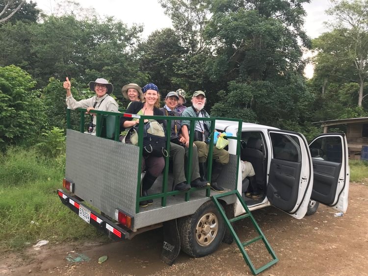 People looking at camera from truck after jungle advernture. Safari Type Truck with People